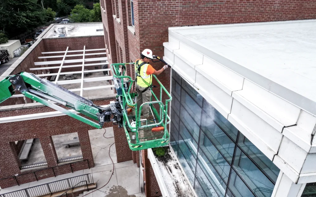 Superior Labor Solutions Employee On Cherry Picker Outside of Construction Site for Power Washing